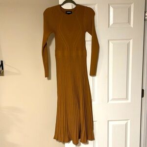 The perfect dress that features a soft sweater material and pleated skirt.